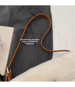 Detail of adjustable brown leather shoulder strap with silver buckle on faux fur bag