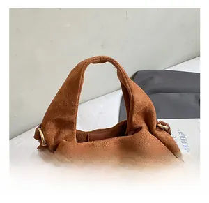 Detail of wide suede handle and golden metal buckle on a brown vintage handbag