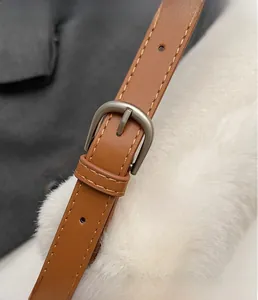 Detailed close-up of brown leather strap with brushed silver buckle and fine stitching