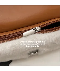 Detailed close-up of the silver hardware zipper and white plush trim on brown leather bag