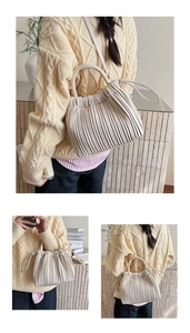 Detailed view of cream pleated bucket bag with elegant accordion folds and soft PU strap