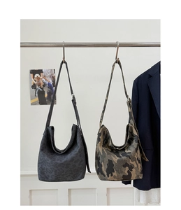 Close-up of hobo shoulder bags featuring camouflage and leopard prints on hanging display