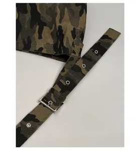 Close-up of camouflage canvas strap featuring polished silver metal buckle and reinforced eyelets