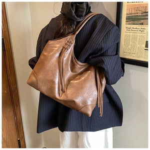 Gros plan d'un grand sac cabas vintage marron avec franges et bandoulière large