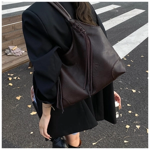 Gros plan sur le sac cabas marron foncé avec détails de glands et similicuir mat