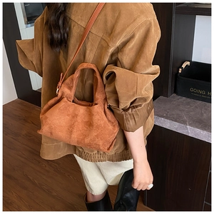 Vue arrière du sac à main en daim caramel dans un décor rétro avec parquet en bois chic