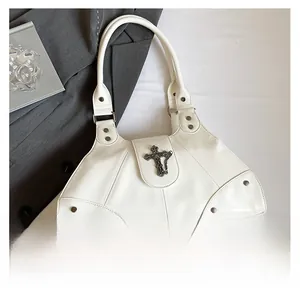 Detailed view of white oil wax leather tote bag with silver cross charm and metal studs