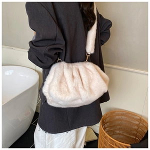 Detailed view of the soft faux fur texture and gold metal buckle on a fluffy cloud bag