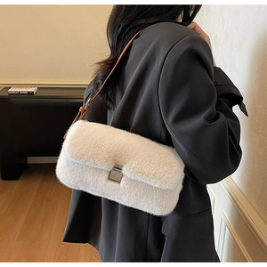 Detail of white plush shoulder bag featuring premium brown leather strap and silver clasp