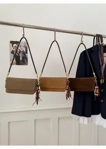 Three retro suede rectangular shoulder bags in olive, tan, and brown with wooden bead tassels