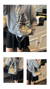 Detail showing the quilted silver puffer bag with metallic texture and crossbody strap