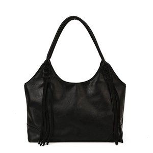 Grand sac cabas minimaliste en cuir noir avec pompon élégant et silhouette hobo moderne