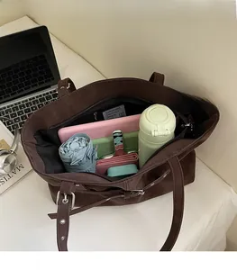 Detail view of large interior space in brown tote bag with various everyday essentials