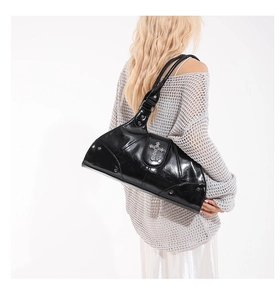 Detail of black patent leather shoulder bag with silver cross and metallic studs decoration