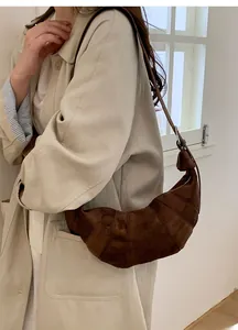 Detailed view of the dark brown suede hobo bag showing texture and slim shoulder strap