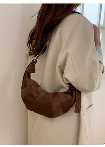 Detail of brown faux suede dumpling bag showing pleats and adjustable strap buckle