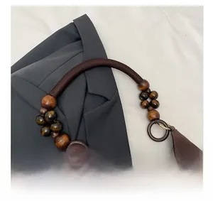 Détail de la poignée en corde tressée avec perles en bois sur un sac cabas rétro