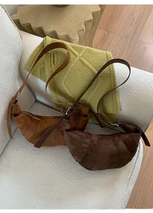 Close-up of caramel and dark brown suede croissant bags with stitching details