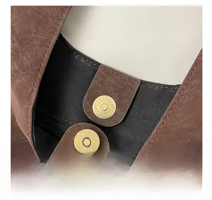 Détail du sac vintage en cuir PU marron avec fermoir magnétique doré et poche zippée