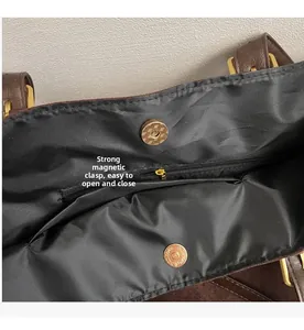 Internal view of brown leather tote bag with magnetic closure and zipper pocket
