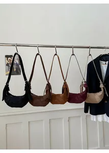 Detail view of various retro suede crescent bags hanging in five different colors