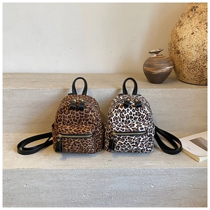 Detail of trendy leopard print mini backpacks in classic brown and white patterns