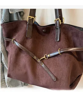 Detail view of large dark coffee tote bag featuring soft suede texture and gold hardware