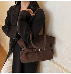 Detail of dark coffee large tote bag featuring matte texture and metal buckle on side
