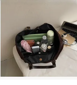 Spacious interior of dark brown matte tote bag holding a laptop and daily essentials