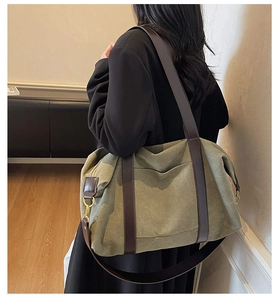 Detail of army green canvas tote with brown straps and brass hardware for commute