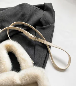 Détail du sac seau en peluche avec bandoulière en cuir réglable et boucle en argent