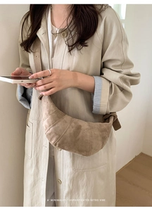 Detail of khaki faux suede croissant bag with knotted strap and minimalist stitching