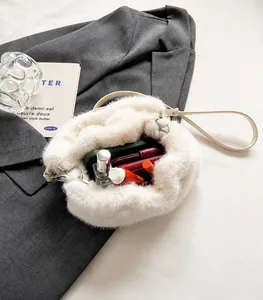 Vue de l'intérieur d'un sac à main en peluche blanche avec espace pour portefeuille et maquillage