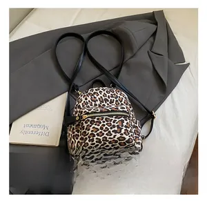 Detail shot of leopard print backpack showing the golden metal zipper and texture