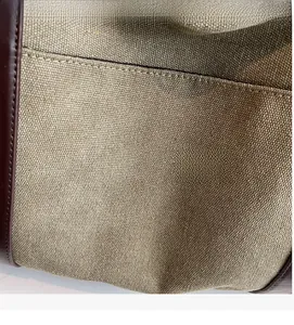 Macro shot of canvas texture and brown leather trim detailing on the shoulder bag