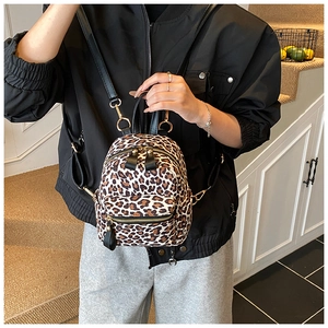 Close-up of leopard print backpack with dual zippers and front pocket detail