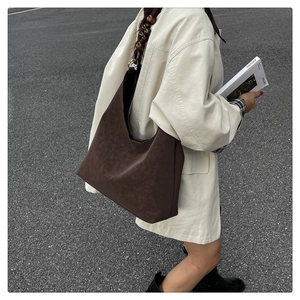 Detail of dark brown suede shoulder bag with unique wooden bead strap and large capacity