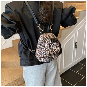 Detail of vintage leopard print backpack with gold zippers and adjustable straps