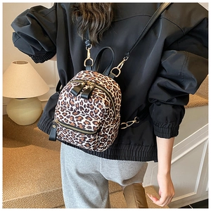 Detailed back view of a mini leopard print backpack with black leather straps and gold zippers