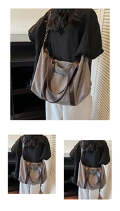 Vertical view of grey canvas tote bag with brown leather handles and shoulder strap