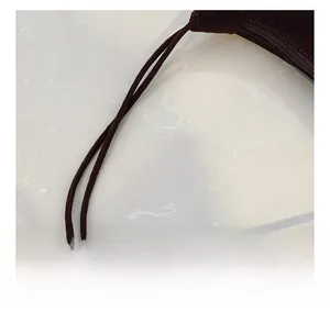 Detail of slim double handles and smooth zipper on dark brown suede shoulder bag