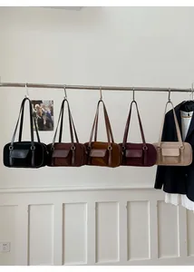 Close-up of five vintage faux suede shoulder bags in black, brown, red and beige color