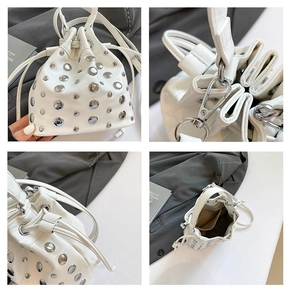 Detail view of white bucket bag with silver studs, drawstring closure and inner pocket
