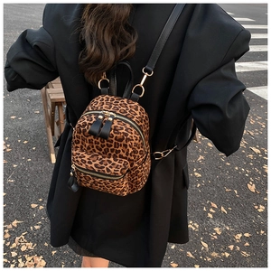 Detail of vintage leopard print backpack with gold metal zippers shown on a model