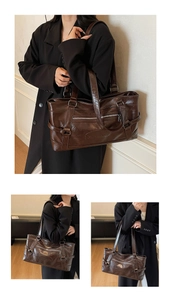 Detail of vintage brown glossy leather tote bag featuring front zipper and belt buckle