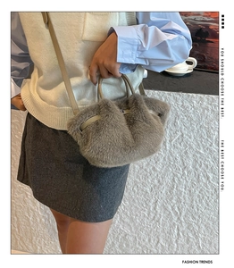 Detailed close-up of grey plush faux fur handbag featuring leather strap and metal lock