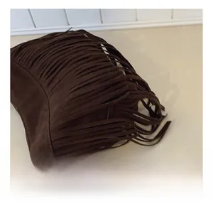 Detail shot of the soft brown suede texture and long fringe tassels on the crossbody bag