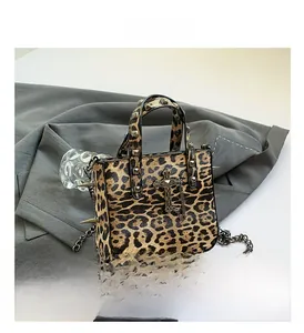 Macro detail of gothic punk leopard print bag with metal rivets and cross pendant