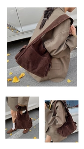 Sac seau en daim marron foncé avec poches latérales et large bandoulière dans un décor d'automne