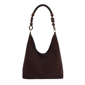 Dunkelbraune Retro Hobo Tasche mit schicken Holzperlen am Riemen vor weißem Grund